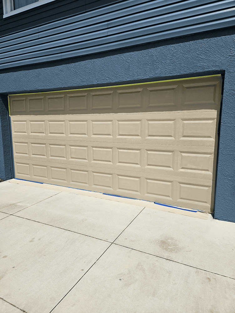 Beige garage door on blue house