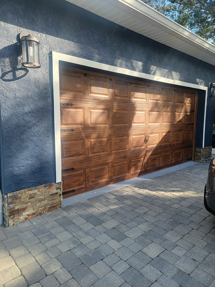 Wooden garage door on blue stucco house