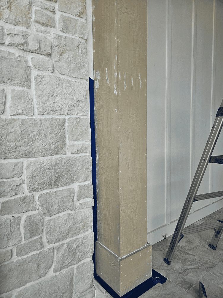 Column with fresh paint beside faux stone wall